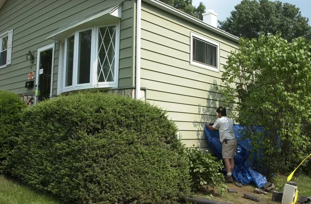 Upper Moreland, PA, June 22, 2001 -- A resident puts up a tarp on a hole that was the result of an implosion from the previous week's flooding from Tropical Storm Allison. Pressure from the water caused the empty basement to collapse. Photo by Liz Roll/FEMA News Photo. Water Damage Restoration Quebec: Montreal Spring Thaw