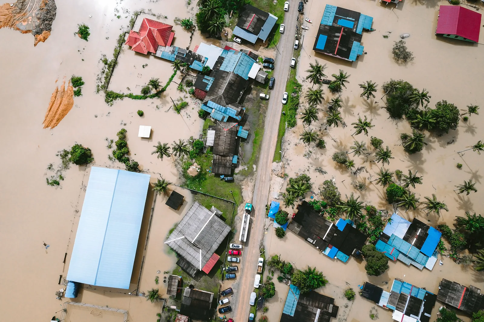 Drone view of a residential area in Kijal, Malaysia, showing extensive flooding and submerged buildings. Water restoration employee pay: a labor-cost framework