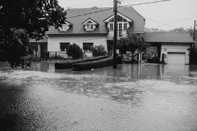 A black and white image showing a suburban house surrounded by floodwater. Water restoration trends that still matter to operators